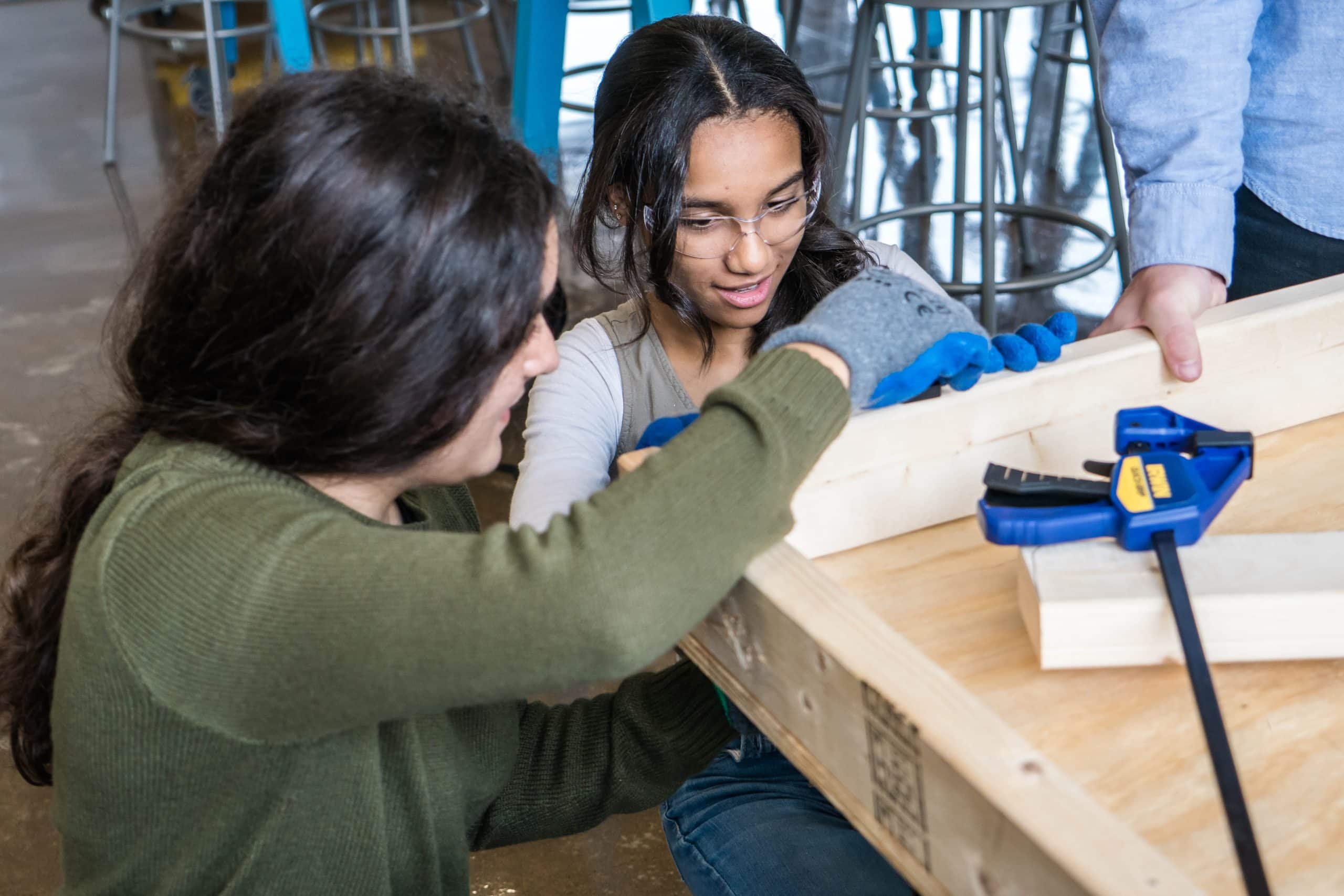 Two students building a wooden table from scratch